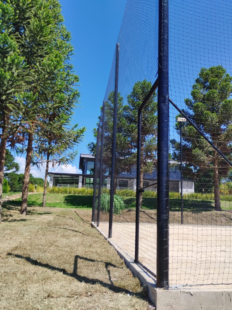 Estrutura de fechamento com tela instalada em quadra esportiva
