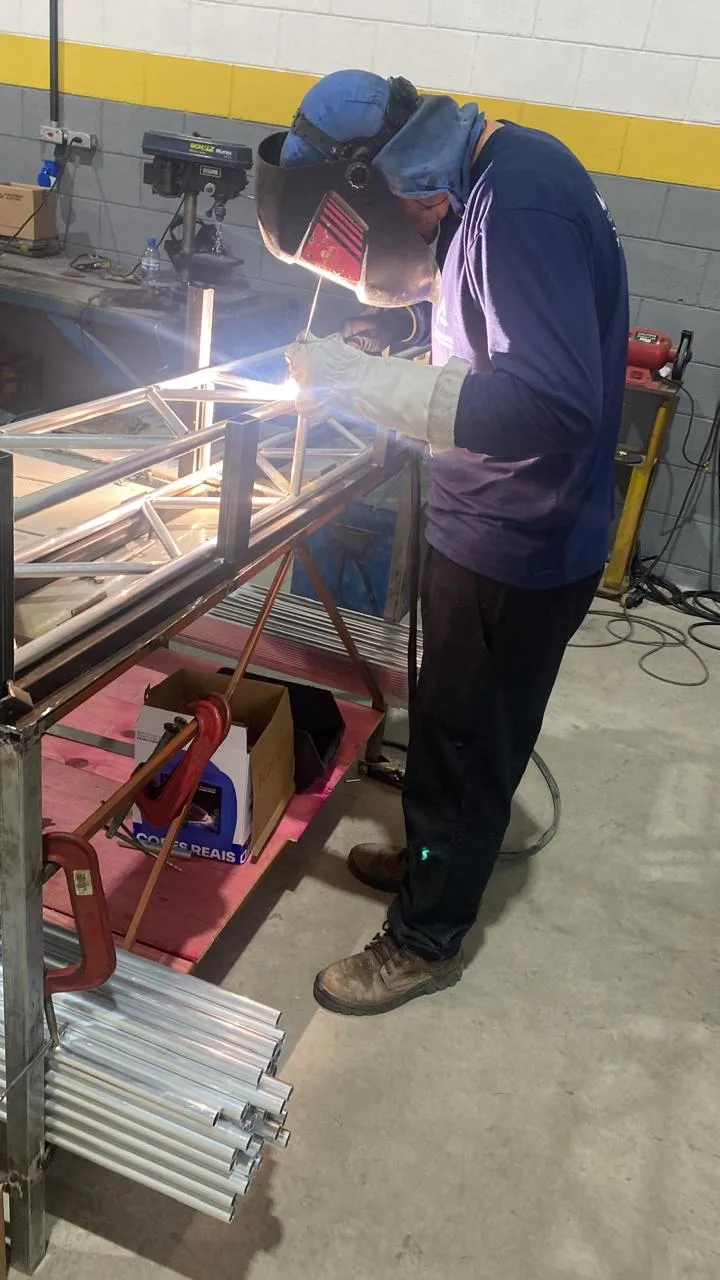 Profissional realizando soldagem em estrutura metálica tubular