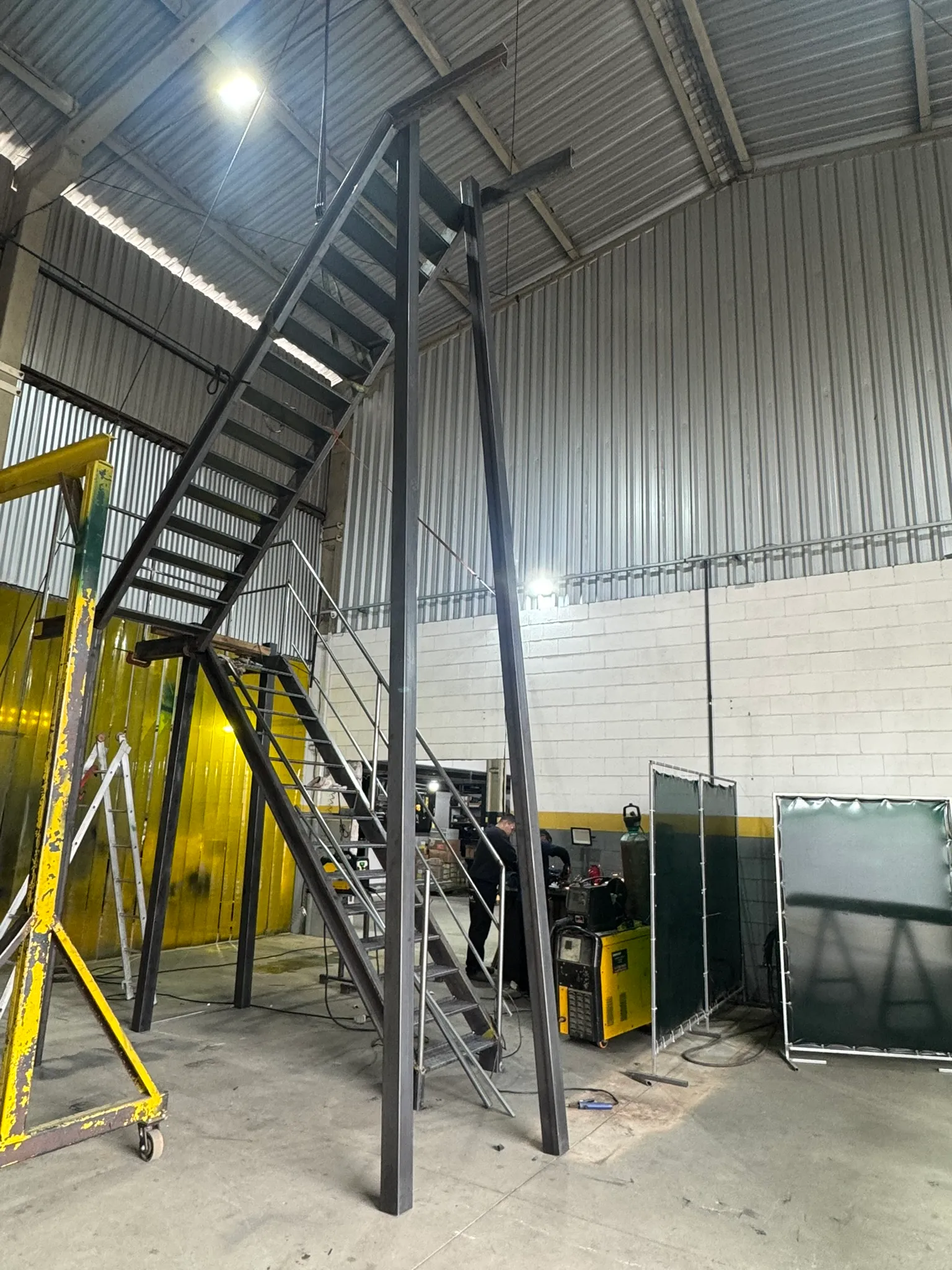 Escada metálica elevada em montagem dentro de oficina