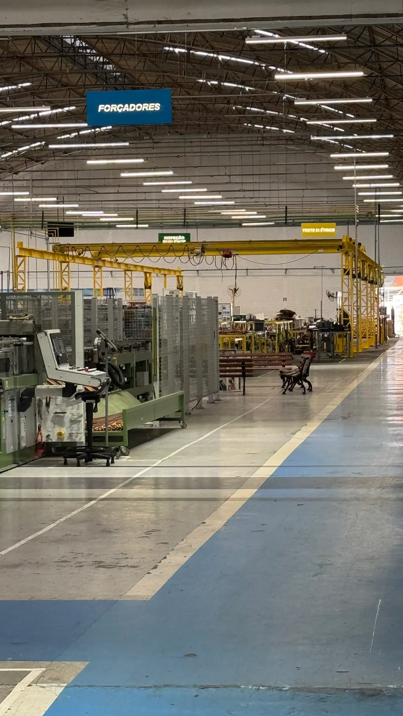 Estrutura metálica amarela ao longo de área de produção industrial